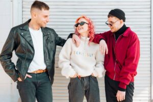 Three friends pose together, dressed in stylish